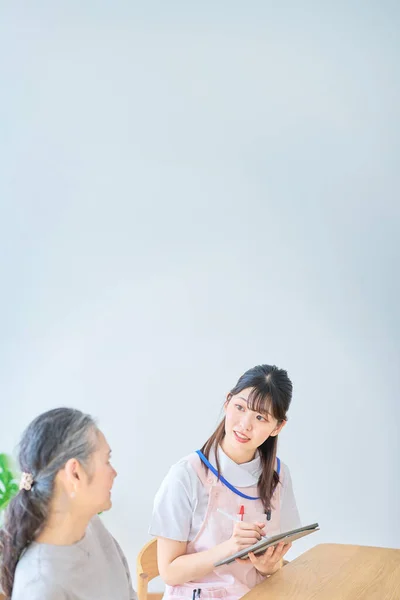 Young Woman Apron Senior Woman Having Conversation Home — Stock Photo, Image