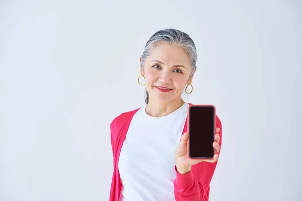 Seniorin Zeigt Smartphone Bildschirm Haus — Stockfoto