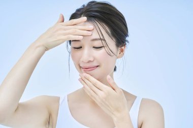 Asyalı orta yaşlı kadın cilt bakımı yapıyor.