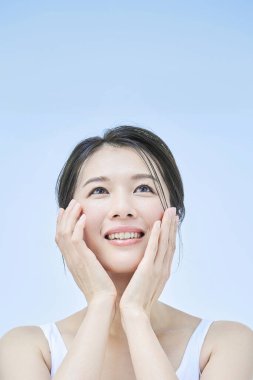 Asyalı orta yaşlı kadın cilt bakımı yapıyor.