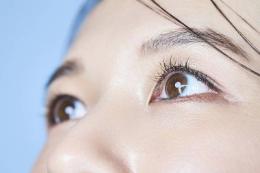 Bir kadının gözlerini kapat ve soluk mavi arka plan