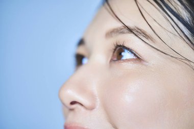 Bir kadının gözlerini kapat ve soluk mavi arka plan