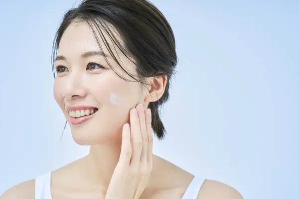 asian middle aged woman doing skin care