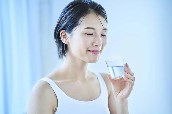 woman drinking a glass of water in the room