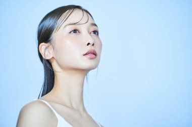 Asyalı genç kadın ve açık mavi arka plan