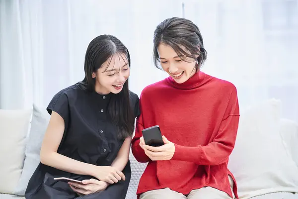 Twee Vrouwen Kijken Naar Smartphone Kamer — Stockfoto