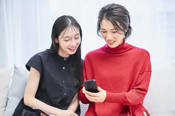 Zwei Frauen Schauen Zimmer Auf Das Smartphone — Stockfoto