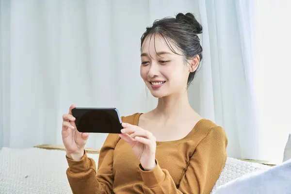 Eine Junge Frau Loungewear Blickt Auf Einen Smartphone Bildschirm Ihrem — Stockfoto