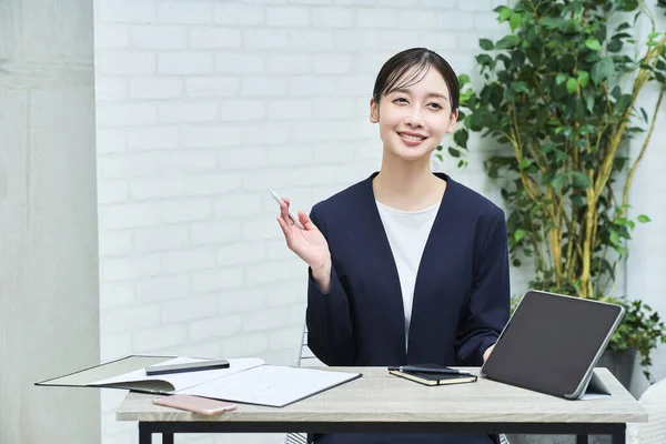 A woman in a suit talking with a smile at office