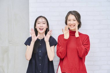 Gülümseyen ve alkışlayan iki kadın