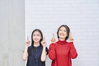 İki Japon kadın içeriyi işaret ediyor.