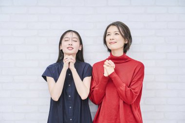 İki Japon kadın dua ederken poz veriyor