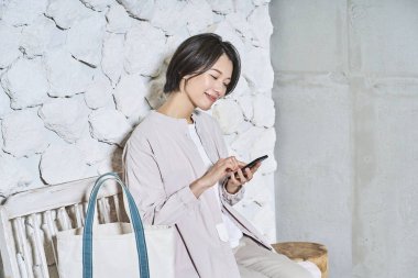 Elinde akıllı telefon tutan gülümseyen kadın.