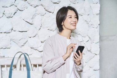 Elinde akıllı telefon tutan gülümseyen kadın.