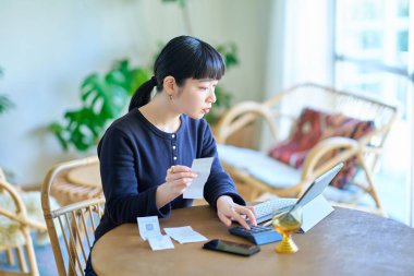 Odada elinde makbuz tutan genç bir kadın var.