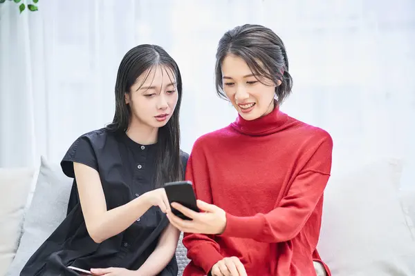 Två Kvinnor Tittar Sina Smartphones Med Oroliga Uttryck — Stockfoto