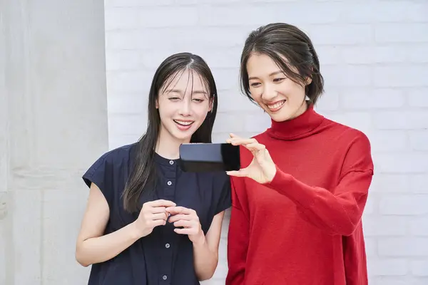 Duas Mulheres Olhando Para Uma Tela Smartphone — Fotografia de Stock
