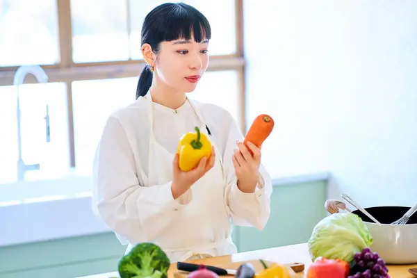 Молодая Женщина Собирает Овощи Кухне — стоковое фото