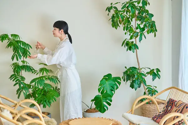 Ung Kvinna Vattnar Krukväxterna Rummet — Stockfoto