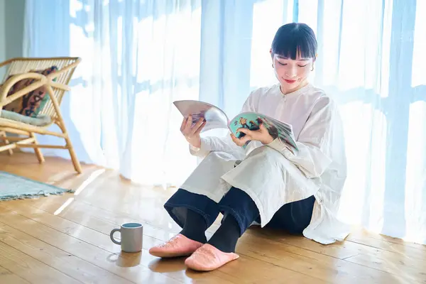 Ung Kvinna Läser Tidning Vid Fönstret Sitt Rum — Stockfoto