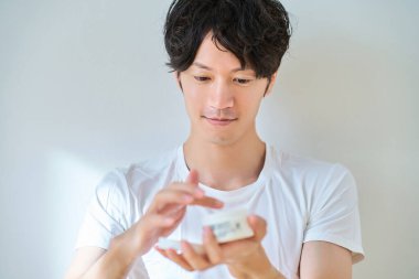 Delikanlı odada cilt bakımı yapıyor.