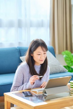 Sıradan bir odada bilgisayarda çalışan bir kadın.