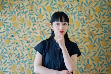 Kapalı bir yerde çenesine yaslanan genç bir kadın