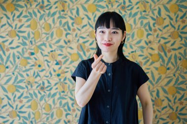 Odada kalp şeklinde genç bir kadın var.