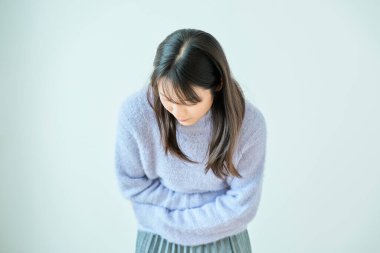 İçeride karın ağrısından muzdarip olan genç bir kadın.