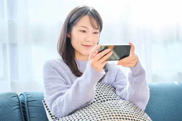 Młoda Kobieta Patrzy Ekran Smartfona Pokoju — Zdjęcie stockowe