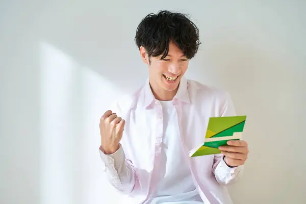Young Man Looking His Bankbook Front White Background — Stock Photo, Image