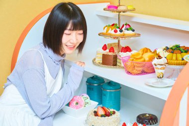 Odada şekerlerle çevrili genç bir kadın.