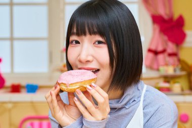 Odada donut tutan genç bir kadın.