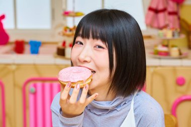 Odada donut tutan genç bir kadın.