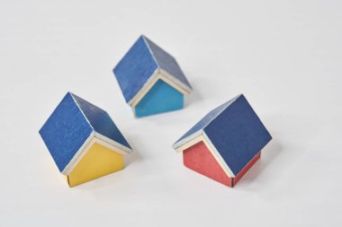 Beyaz bir masanın üzerine dizilmiş birden fazla evin modelleri.