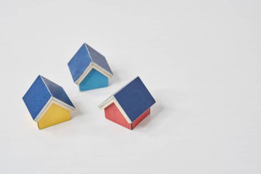 Beyaz bir masanın üzerine dizilmiş birden fazla evin modelleri.