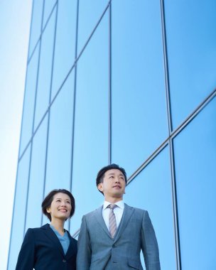 Güzel bir günde takım elbiseli kadın ve erkek modern mimari