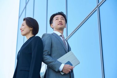 Güzel bir günde takım elbiseli kadın ve erkek modern mimari