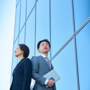 Güzel bir günde takım elbiseli kadın ve erkek modern mimari