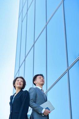 Güzel bir günde takım elbiseli kadın ve erkek modern mimari