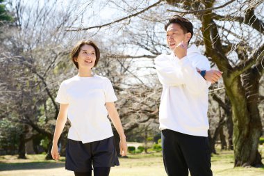 Erkek ve kadın güzel bir günde ısınma egzersizi yapıyorlar.