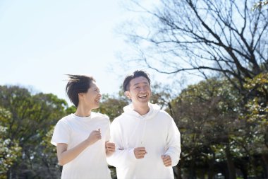 Erkek ve kadın güzel bir günde yan yana koşuyorlar.