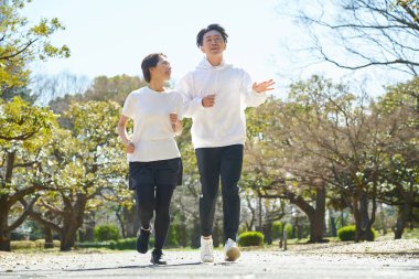 Erkek ve kadın güzel bir günde yan yana koşuyorlar.