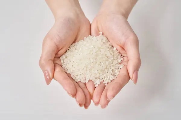stock image A cup of rice in the hand and white background
