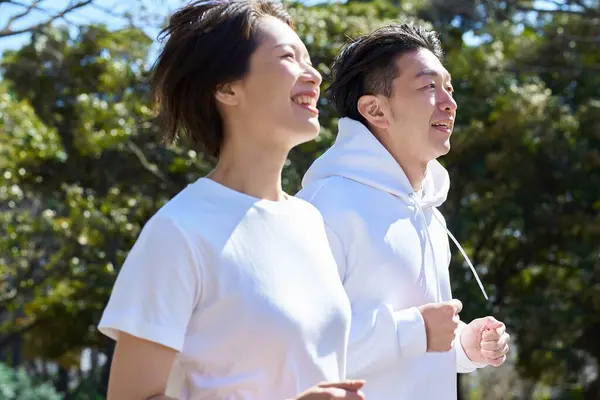 stock image Man and woman running side by side on fine day