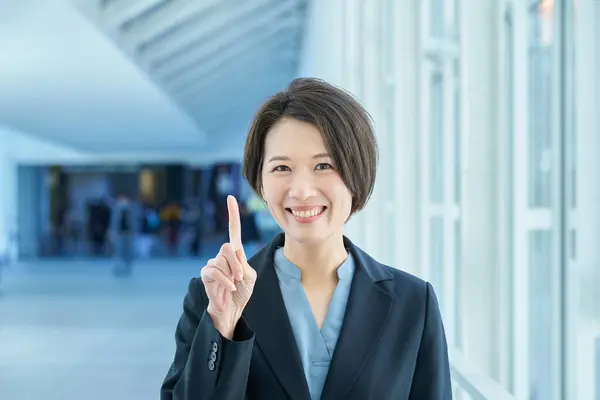 Eine Geschäftsfrau Lächelt Und Hebt Den Zeigefinger — Stockfoto