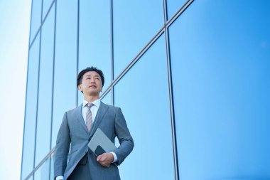 Takım elbiseli bir iş adamı gökyüzüne bakıyor.