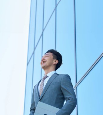 Takım elbiseli bir iş adamı gökyüzüne bakıyor.