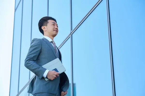 stock image Businessman in a suit looking up at the sky outdoors