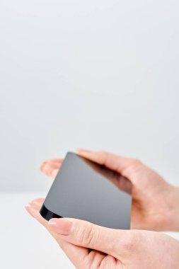 Akıllı telefon ve beyaz arka plan taşıyan bir kadının eli